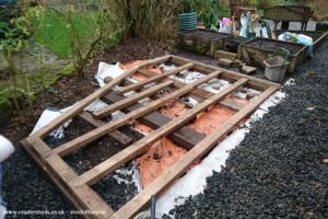 Recycled wood base laid on recycled timber skids on recycled weed suppressant. of shed - Built not bought , Derbyshire