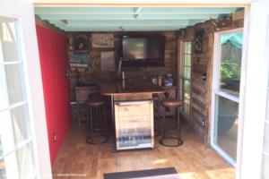 Inside view with pallet walls, bamboo floor, kegerator, tv, bottle cooler, sink, bar of shed - The Hop & Hoe, North Carolina