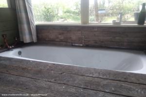 When you get a free bath, what else can you do but sink it in the floor = of shed - Shack attack, Surrey