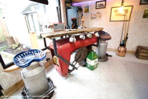 Bar made up of a transmission case, front axle casting and a bonnet, with the last orders bell coming from a fergy potato planter. of shed - Man Cave, Lancashire