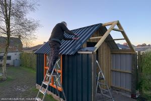 Putting the metal sheet cladding on of shed - Calm Cabin, County Durham